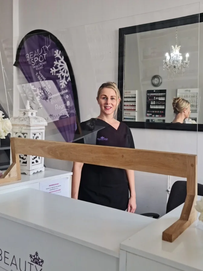 The Beauty Spot owner smiling behind the reception desk