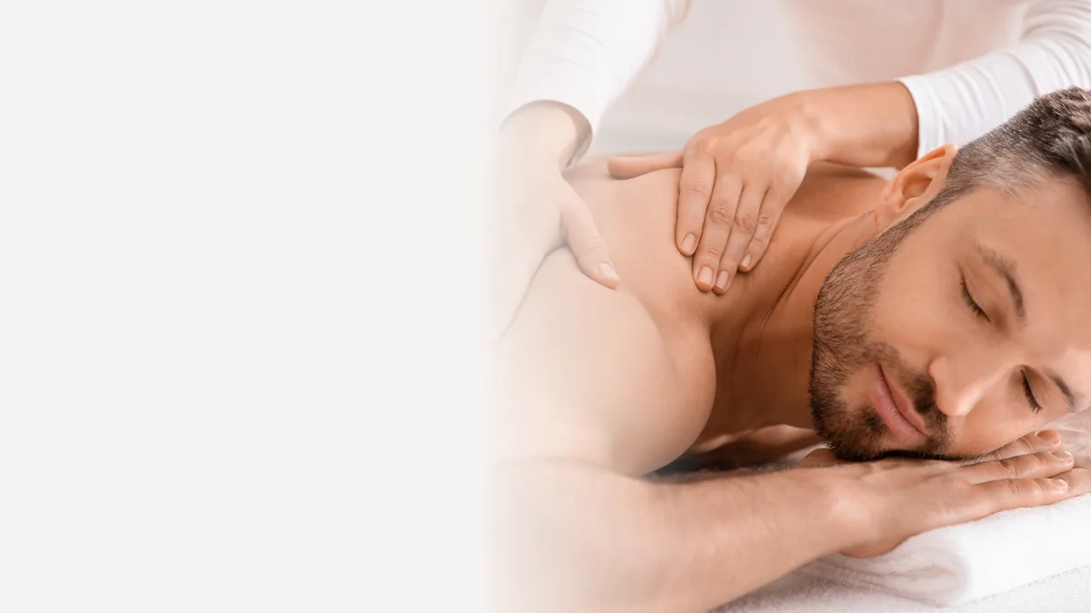 Therapist massaging a relaxed man's shoulders