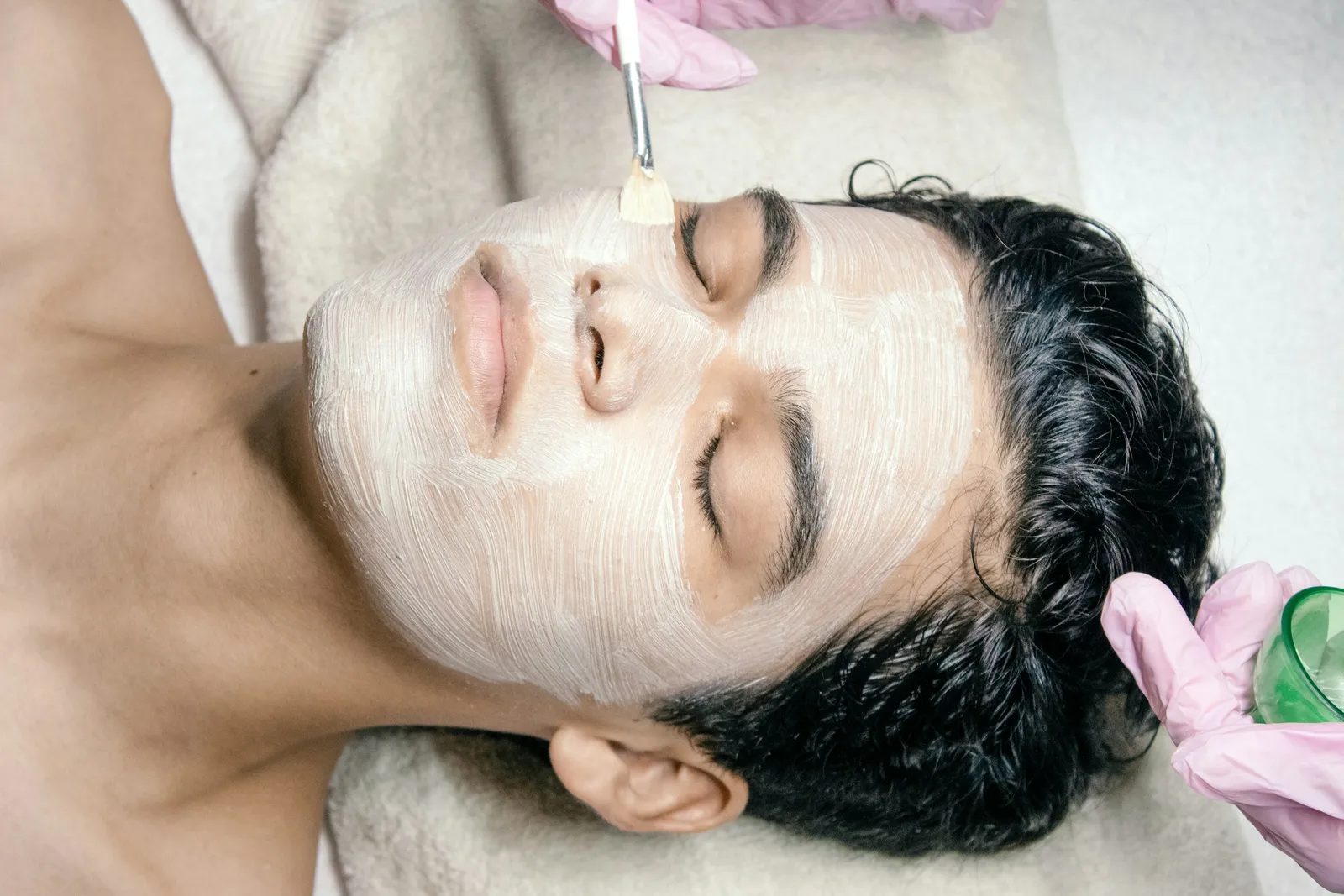Man receiving a facial mask treatment