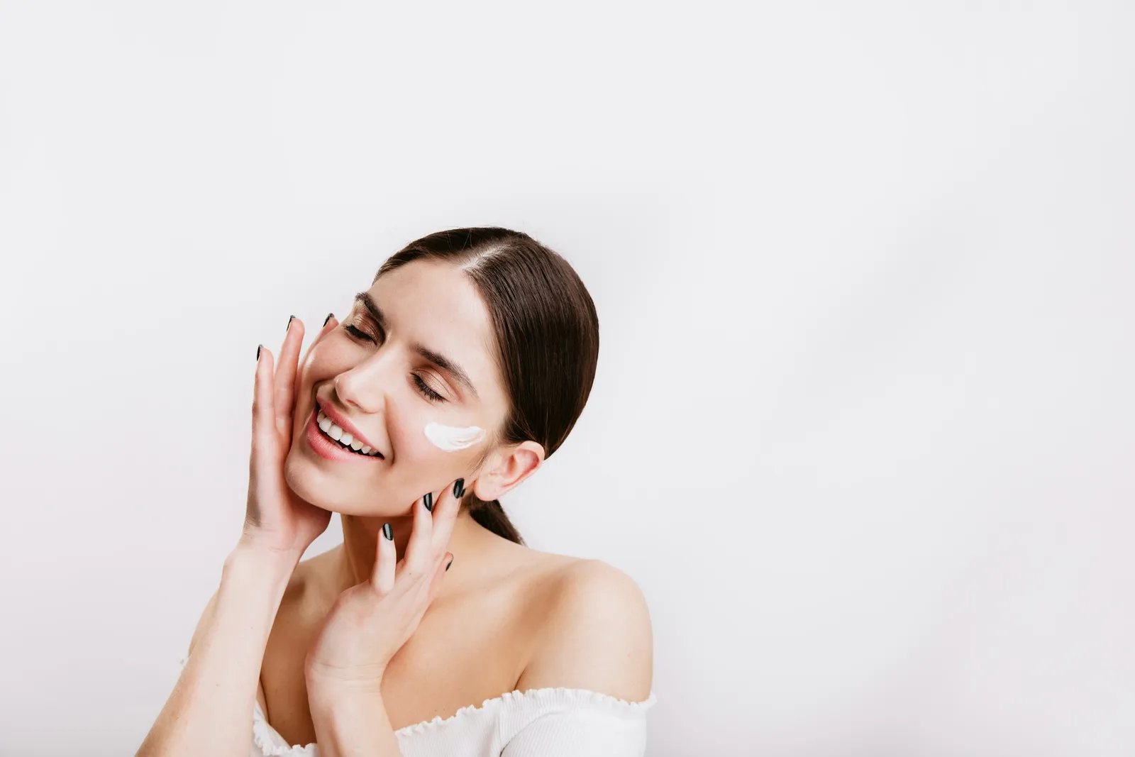 Woman smiling with cream on her cheek